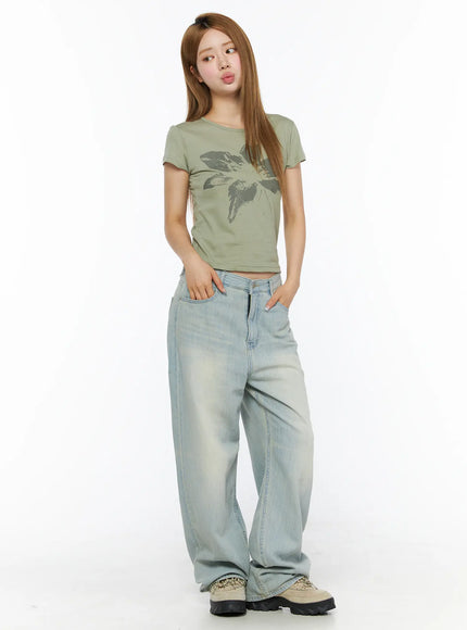 Floral Graphic Tee CL501 dark green full-body front shot on model hands in pockets cropped silhouette with oversized faded wide-leg jeans and chunky sneakers