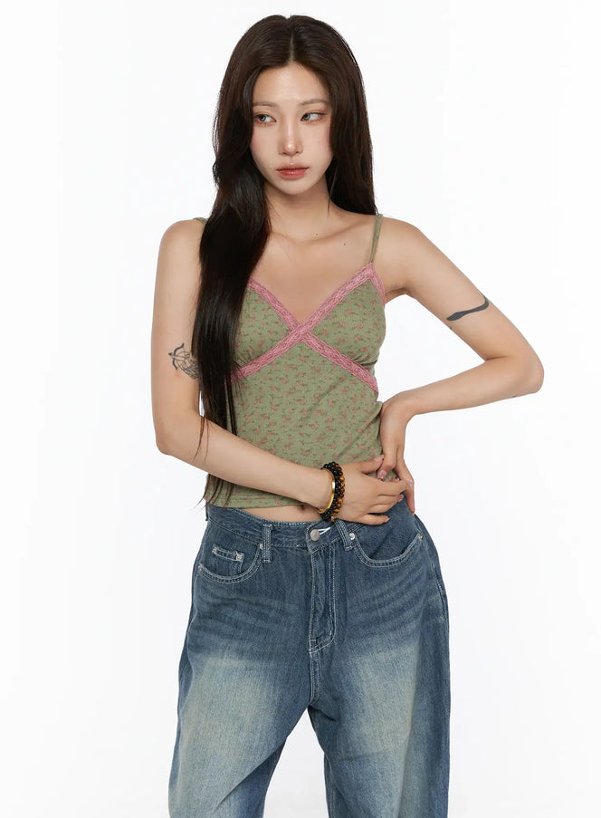 Floral Lace Trim Cami CU530 Green front shot model standing wearing green floral ribbed cami with pink lace V-neck cross trim paired with blue wide-leg jeans