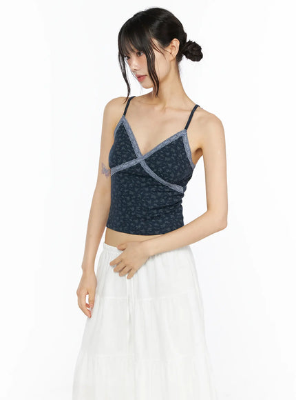 Floral Lace Trim Cami CU530 Navy side shot model standing wearing navy floral ribbed cami with grey lace cross V-neck trim paired with white tiered maxi skirt