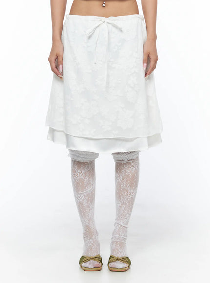Floral Midi Skirt CU523 White front cropped shot on model showing bow tie waistband and floral jacquard upper layer over satin underlayer
