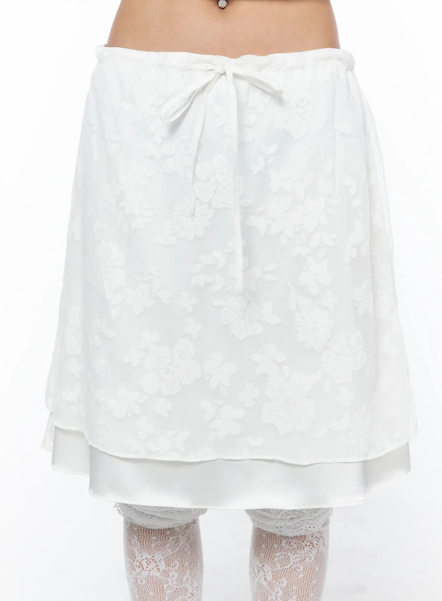 Floral Midi Skirt CU523 White close-up front shot on model highlighting tonal floral jacquard fabric, center bow tie waist, and layered hem detail