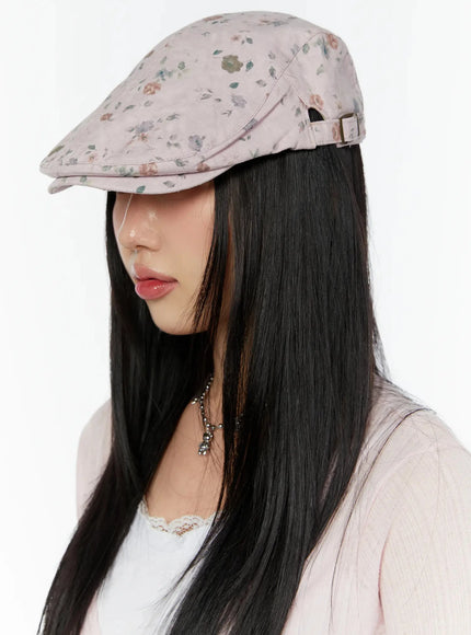 Floral Print Flat Cap IU524 Pink side model shot looking down, gold adjustable buckle at back, soft rose and leaf print visible