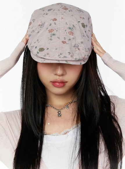 LEWKIN Floral Print Flat Cap IU524 Pink front model shot with both hands lifting brim over eyes, ditsy rose print, styled with lace top