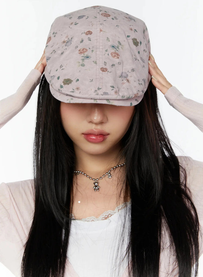 LEWKIN Floral Print Flat Cap IU524 Pink front model shot with both hands lifting brim over eyes, ditsy rose print, styled with lace top
