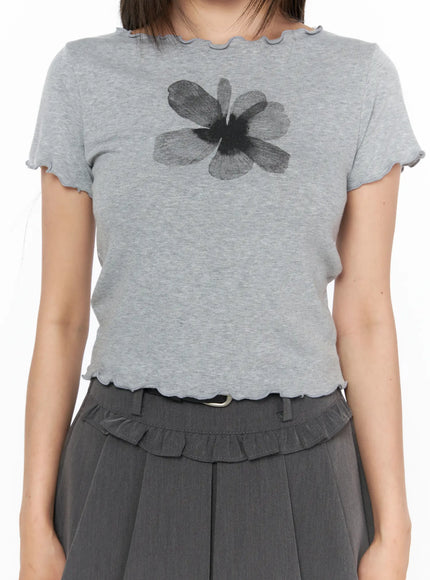 Floral Print Tee CL517 Gray close-up front shot model showing large dark flower graphic print on heather gray ribbed fabric with scalloped neckline and lettuce-edge hem detail