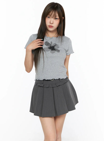 Floral Print Tee CL517 Gray front shot model holding hair, wearing fitted ribbed tee with dark floral print and lettuce-trim neckline, paired with dark gray ruffle-waist pleated mini skirt