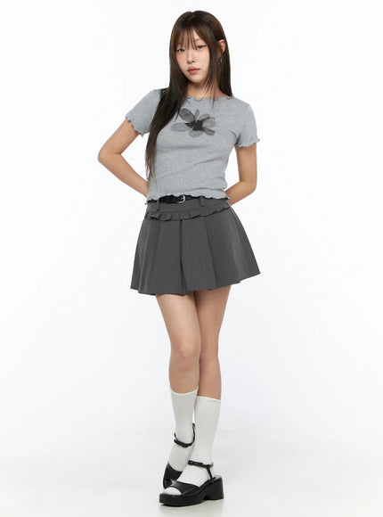 Floral Print Tee CL517 Gray front full-body shot model wearing fitted short-sleeve ribbed tee with dark flower print and scallop hem, styled with gray pleated mini skirt and white knee socks
