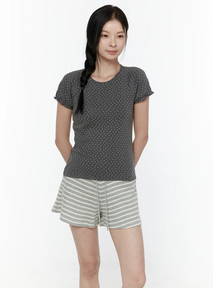 Floral Puff Short Sleeve Top IL506 Charcoal Gray front view on model with braided hair hands in pockets showing allover dot print and frill sleeves