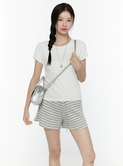 LEWKIN Floral Puff Short Sleeve Top IL506 White S/M front view on model wearing braided hair with silver crossbody bag and gray striped shorts