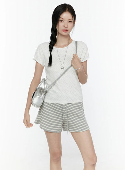 LEWKIN Floral Puff Short Sleeve Top IL506 White S/M front view on model wearing braided hair with silver crossbody bag and gray striped shorts