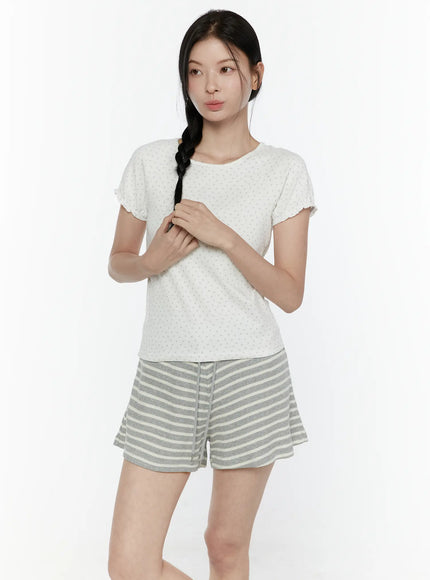 Floral Puff Short Sleeve Top IL506 White front view on model with hands clasped at chest gazing to the side styled with gray striped mini shorts