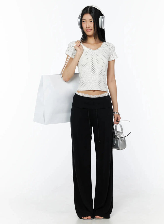 Fold-Over Drawstring Sweatpants IL509 Black full-body front styling shot model holding shopping bag wearing headphones and silver mini bag