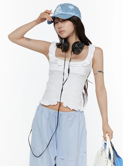 LEWKIN Frill Button Sleeveless Top CL507 White S/M close-up front on model wearing blue cap and headphones, ruffled neckline and hem detail visible