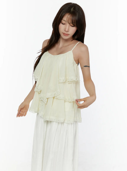 Frill Tiered Lace Sleeveless Top CL507 Cream front shot on model in relaxed pose with arms extended showing tiered ruffle silhouette and lace trim