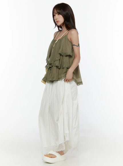 Frill Tiered Lace Sleeveless Top CL507 Dark green side shot on model showing tiered ruffle volume and lace hem detail with white pleated skirt