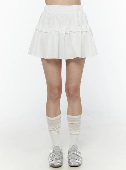 LEWKIN Frill Tiered Mini Skirt IL506 White front shot on model wearing white knee socks and silver flats, elastic waistband and double ruffle tiers visible