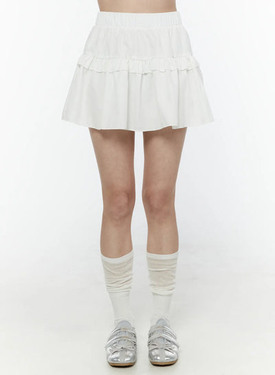 LEWKIN Frill Tiered Mini Skirt IL506 White front shot on model wearing white knee socks and silver flats, elastic waistband and double ruffle tiers visible