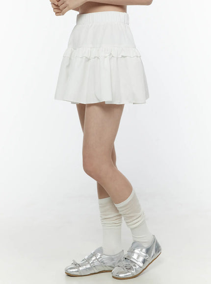 Frill Tiered Mini Skirt IL506 White side shot on model standing straight, showcasing elastic waistband, ruffle tier layers and mini length silhouette