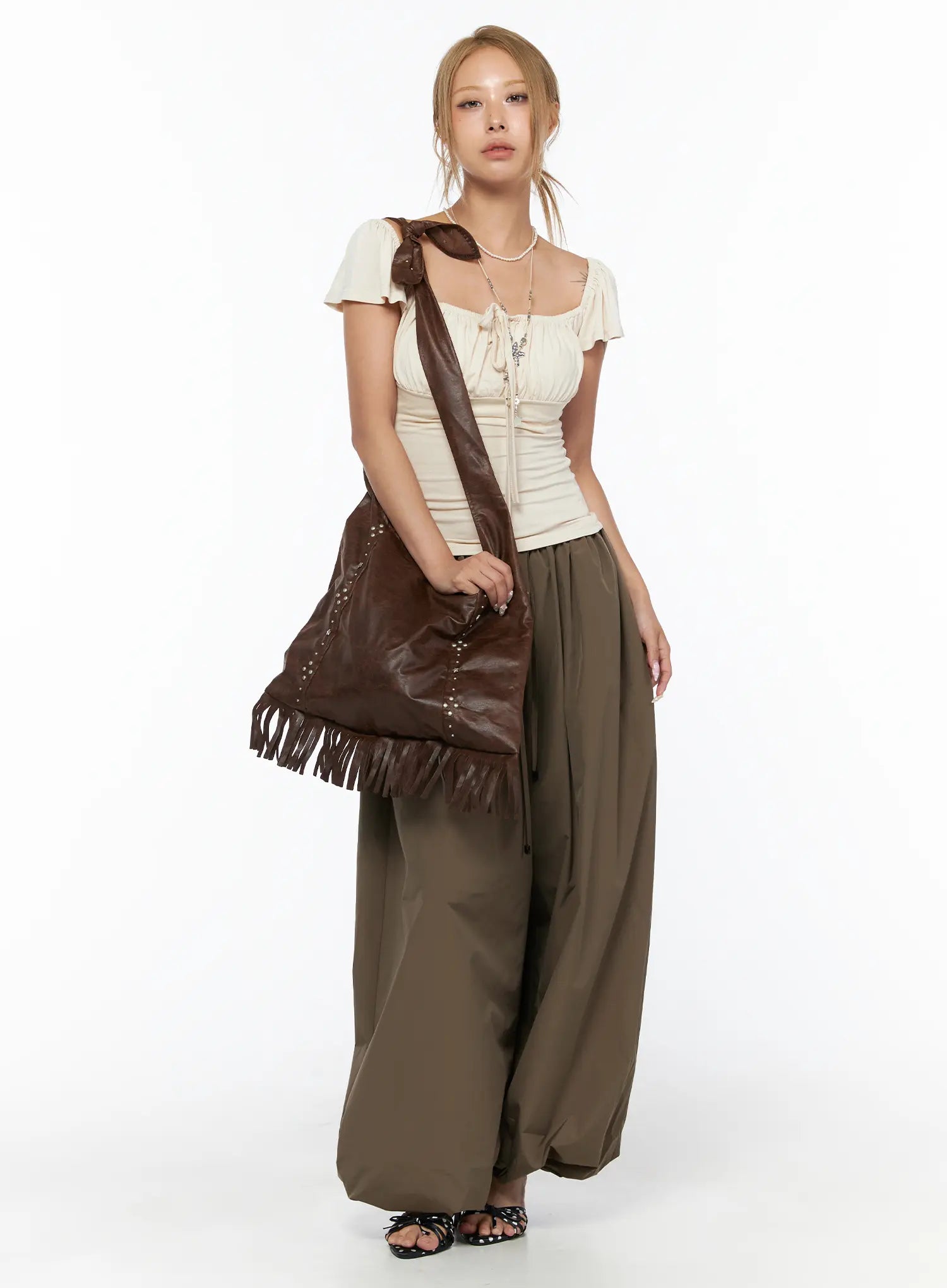 Fringe Studded Shoulder Bag CU524 Brown close-up detail of silver pearl and star studs arranged vertically on distressed brown faux leather body