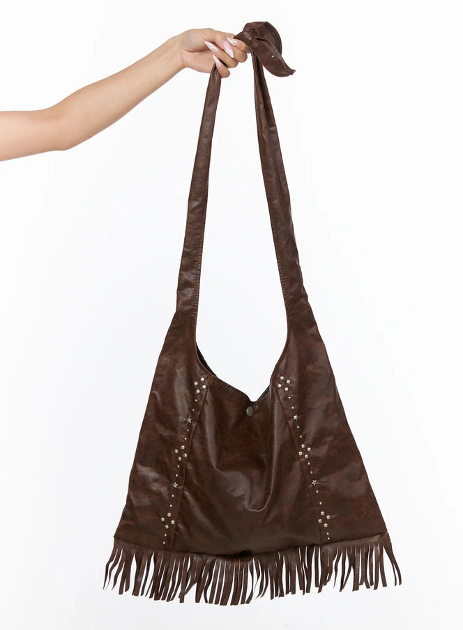 LEWKIN Fringe Studded Shoulder Bag CU524 Brown front hanger shot held by model hand showing full bag silhouette with fringe hem and silver studs
