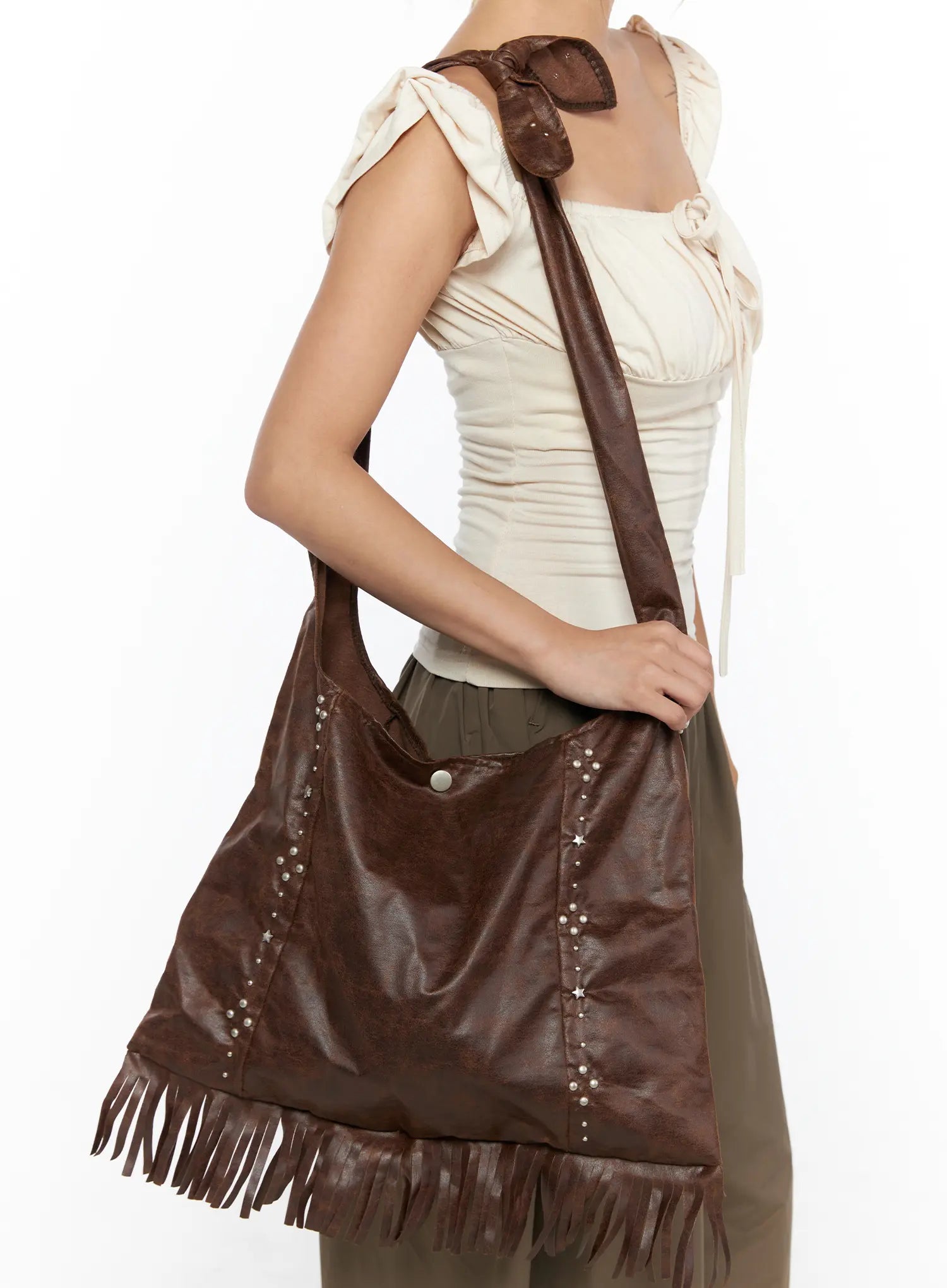 Fringe Studded Shoulder Bag CU524 Brown front view model full-body shot carrying bag at side with cream top olive balloon pants and heels