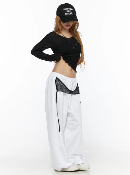 Garter Belt Graphic Wide-Leg Sweatpants CL528 White side view on model styled with black crop top and cap, showing lace garter trim and wide-leg drape