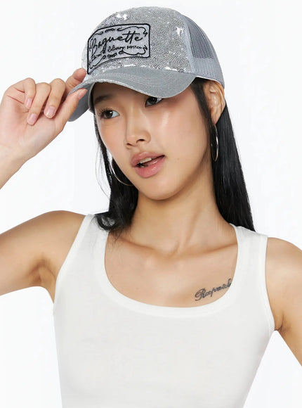 Glitter Patch Trucker Cap IL509 Silver front on model one hand touching brim sequin finish Baguette patch styled with white tank top