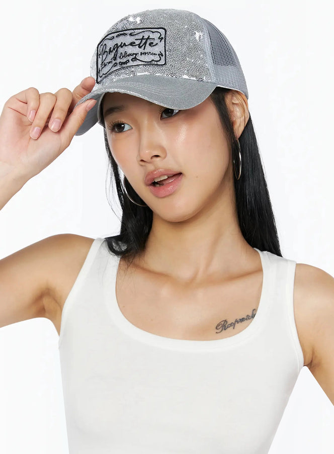 Glitter Patch Trucker Cap IL509 Silver front on model one hand touching brim sequin finish Baguette patch styled with white tank top