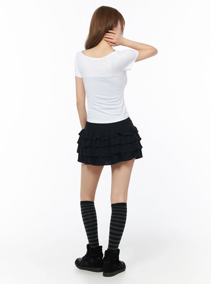 Gothic Cross Slim Fit Top IU525 White back model shot, clean plain back view, scoop neckline, slim stretchy fabric, paired with black tiered ruffle mini skirt