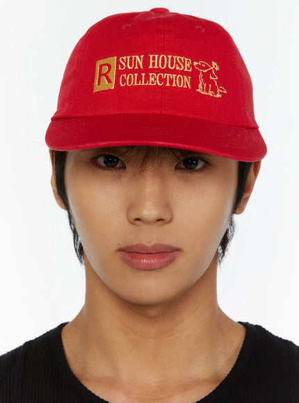 Graphic Baseball Cap IL515 Red three-quarter front model close-up showing gold Sun House Collection embroidery and structured six-panel twill crown