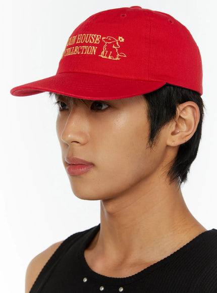 Graphic Baseball Cap IL515 Red side model close-up showing brim profile and partial gold embroidered dog graphic on structured cotton panel