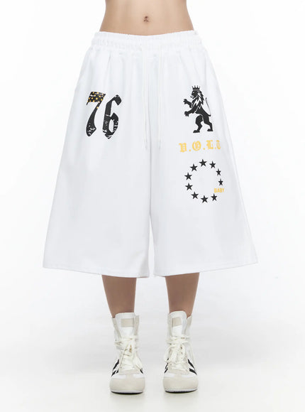 Graphic Bermuda Shorts CL524 White front on model showing full graphic panel with 76, lion crest, V.O.L.T and star circle BABY print, knee-length hem