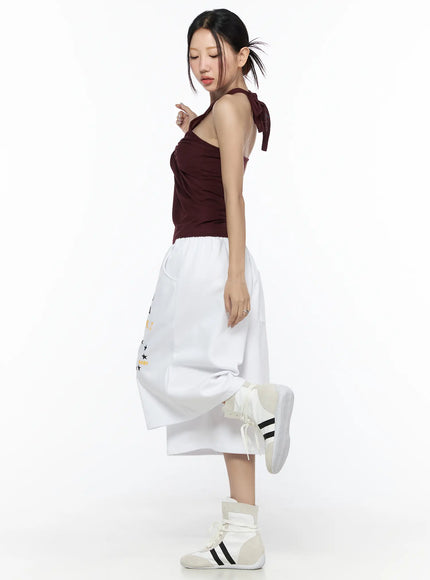 Graphic Bermuda Shorts CL524 White side full-length on model in dynamic one-leg-raised pose showing wide culottes silhouette and hem length