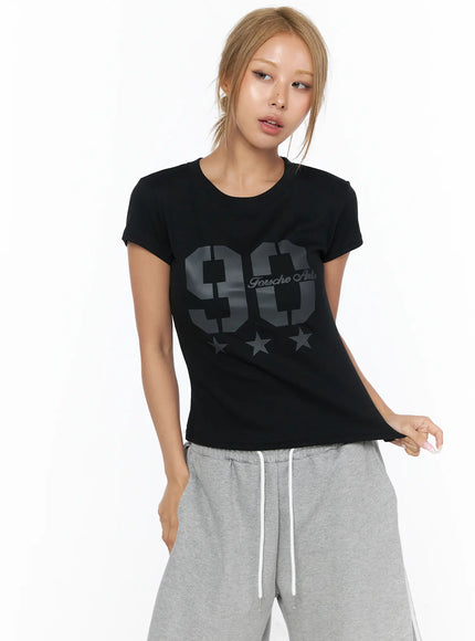 Graphic Crop Tee CU523 Black front shot on model, tone-on-tone dark gray 90 star graphic print, slim crop silhouette, styled with gray drawstring wide-leg pants