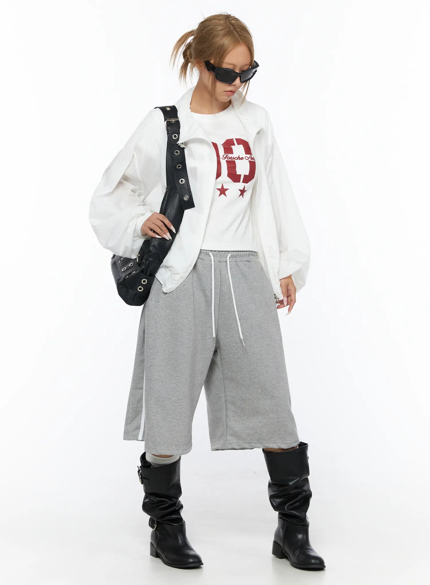 Graphic Crop Tee CU523 White styling shot on model looking down, layered under white oversized jacket with black bag and sunglasses, red 90 graphic visible, sporty outfit