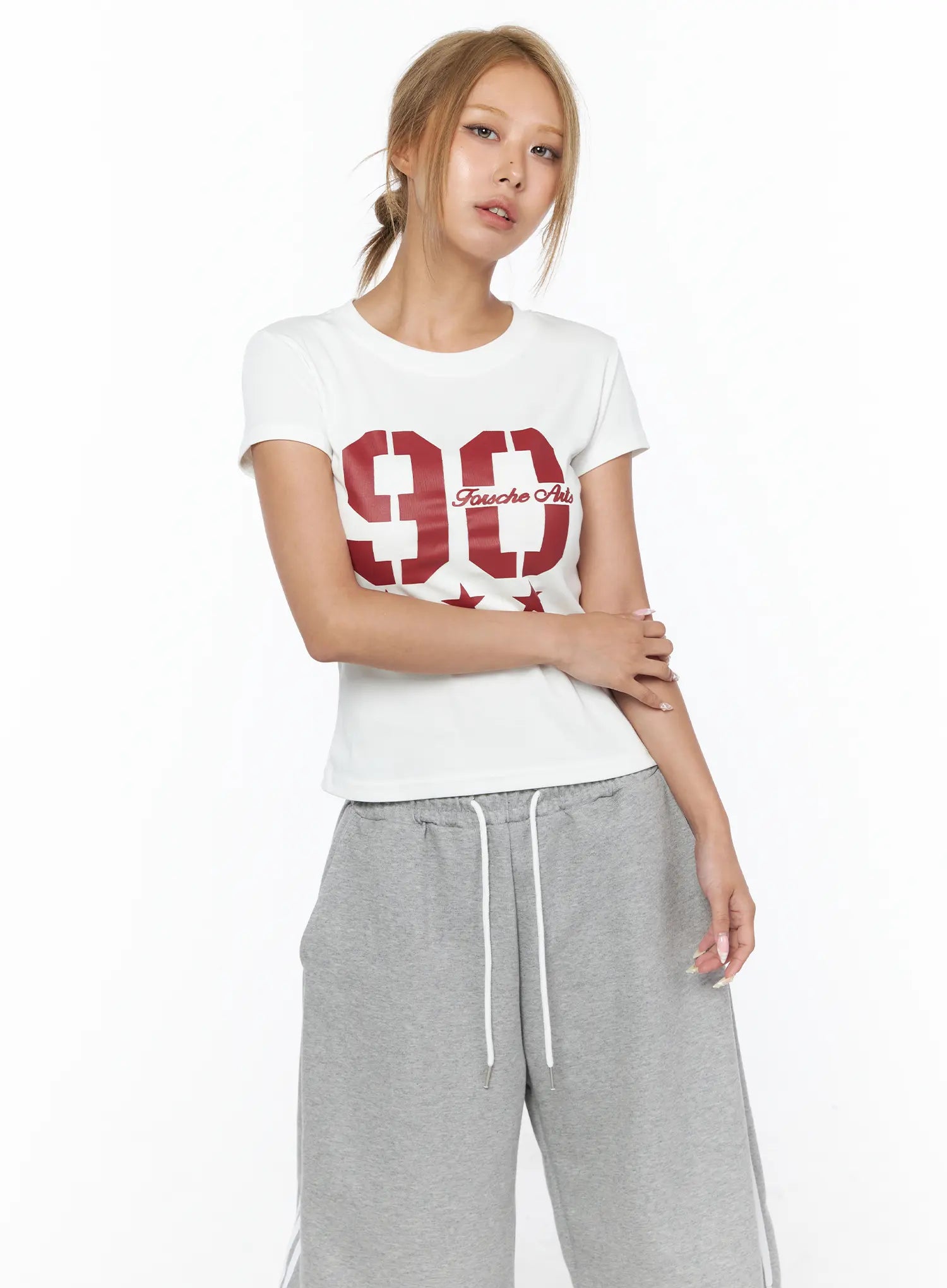 Graphic Crop Tee CU523 White close-up front shot on model with arms crossed, bold red 90 Fousche Arts star print on chest, round neck, short sleeve cotton crop tee