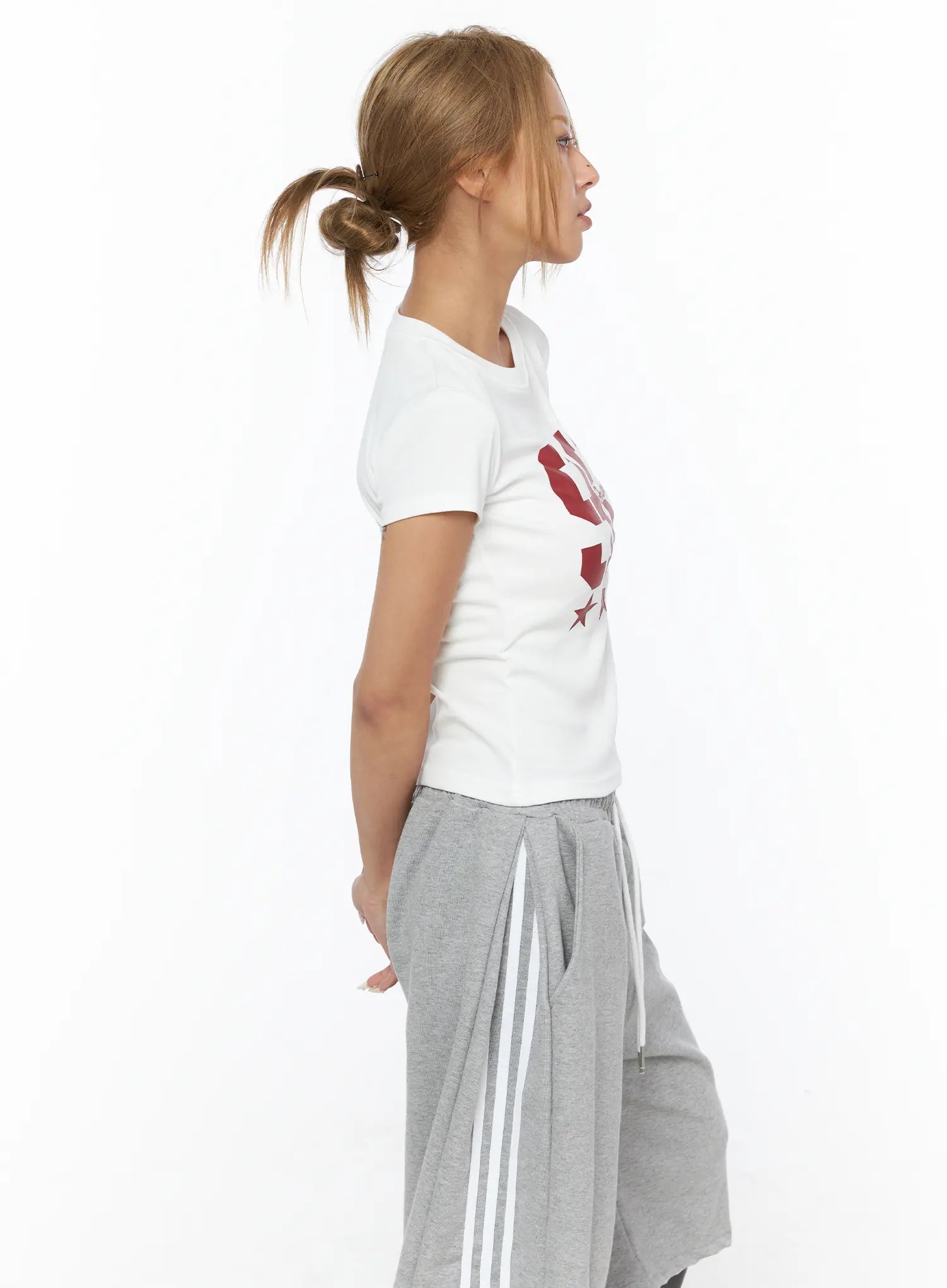 Graphic Crop Tee CU523 White side profile shot on model, red 90 star graphic on chest, slim cropped cotton tee, styled with gray wide-leg drawstring pants