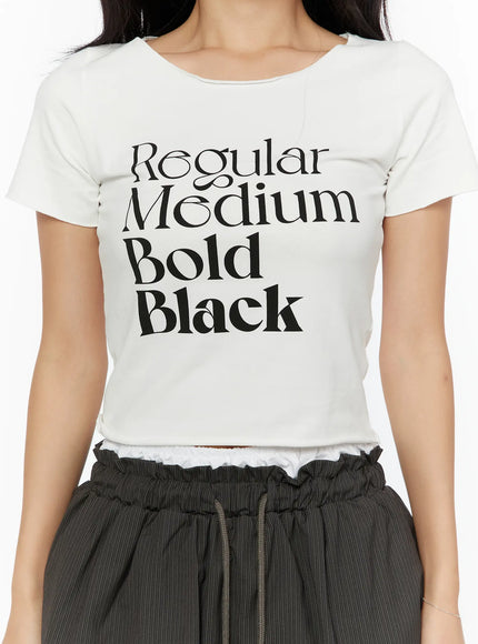 Graphic Cropped Tee CU526 White close-up detail shot showing Regular Medium Bold Black typography print, scoop neckline and ribbed cotton fabric texture