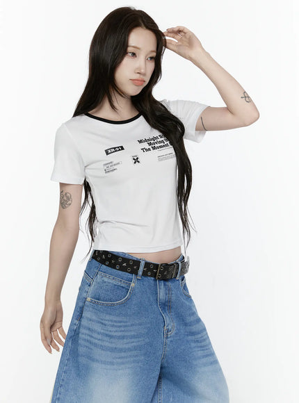 Graphic Cropped Tee IL521 White front view on model with hand raised to head, black ringer neckline, XR-91 badge and archive graphic print, styled with wide-leg jeans