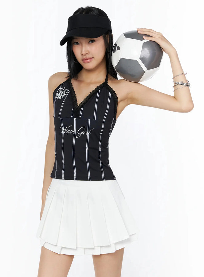 LEWKIN Graphic Lace Halter Top IL509 Black front model shot wearing cap holding soccer ball styled with white pleated mini skirt S/M
