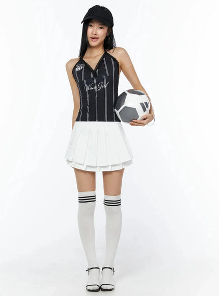 Graphic Lace Halter Top IL509 Black full-body front model shot smiling wearing cap holding soccer ball styled with white layered skirt and knee-high socks