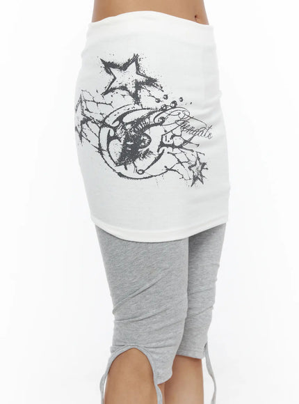 Graphic Layered Skort CL503 Gray close-up front detail of white mini skirt with large dark wing, star, and script graphic print on cotton fabric