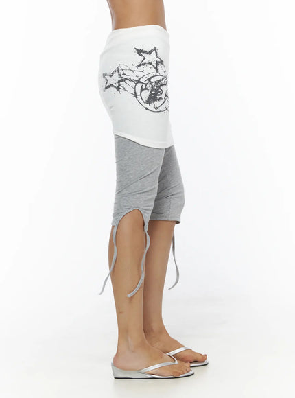 Graphic Layered Skort CL503 Gray side shot on model highlighting white skirt layer with star-and-wing print and gray ruched capri leggings with drawstring