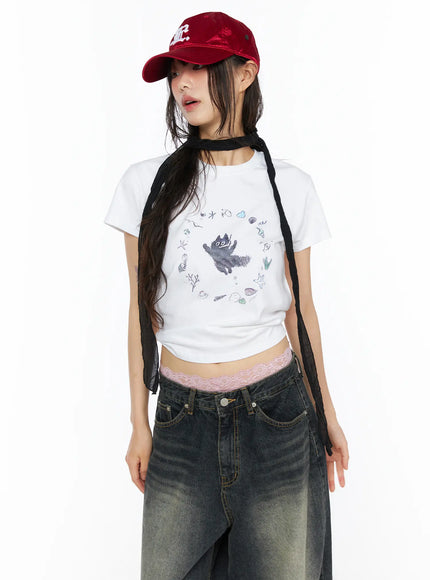 Graphic Meow Crop Tee CU530 White front half-body model wearing red cap and black neck scarf ocean circular graphic print cropped silhouette with lace waistband detail