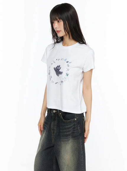 Graphic Meow Crop Tee CU530 White side-angle model standing showing fitted crop length ocean circle print styled with red cap and black neck scarf