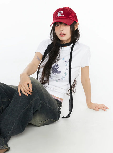 LEWKIN Graphic Meow Crop Tee CU530 White S/M front model seated on floor wearing red cap black neck scarf and wide-leg jeans ocean creature circle print