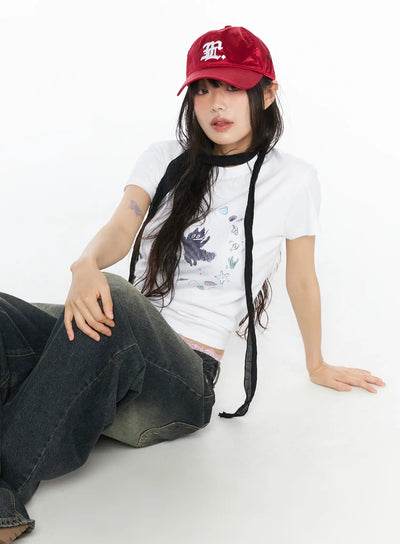 LEWKIN Graphic Meow Crop Tee CU530 White S/M front model seated on floor wearing red cap black neck scarf and wide-leg jeans ocean creature circle print