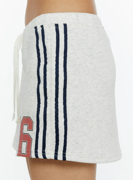 Graphic Mini Skirt CL515 Light Gray close-up side shot on model showing three navy vertical stripes, drawstring tie, and red 76 print on heathered fleece