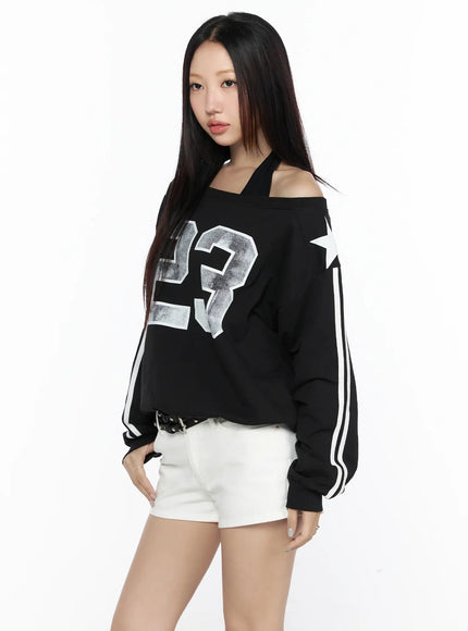 Graphic Off-Shoulder Sweatshirt CL527 Black side shot on model with white star sleeve print paired with white denim shorts