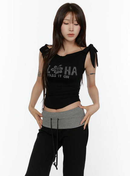 Graphic Off-Shoulder Top CL508 Black front model eyes-down pose rhinestone ALOHA hibiscus PASS IT ON graphic bow-tie shoulders ruched cropped fit